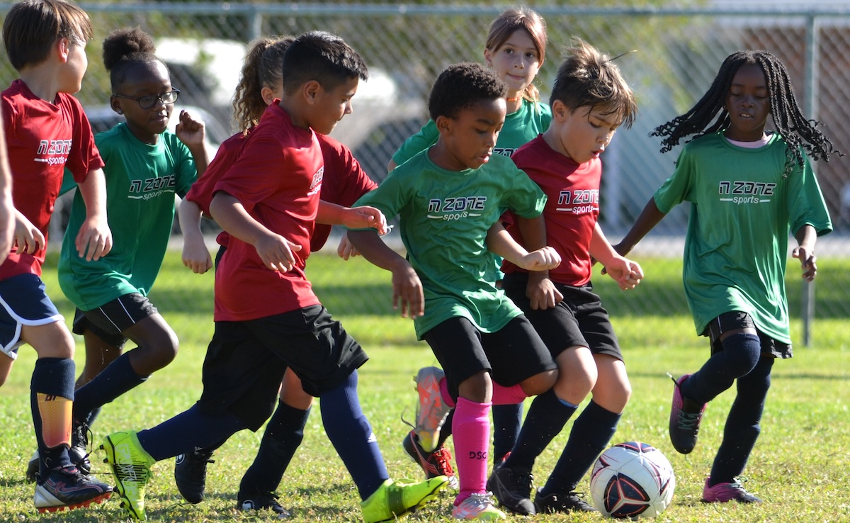 Children bunching around the ball.
